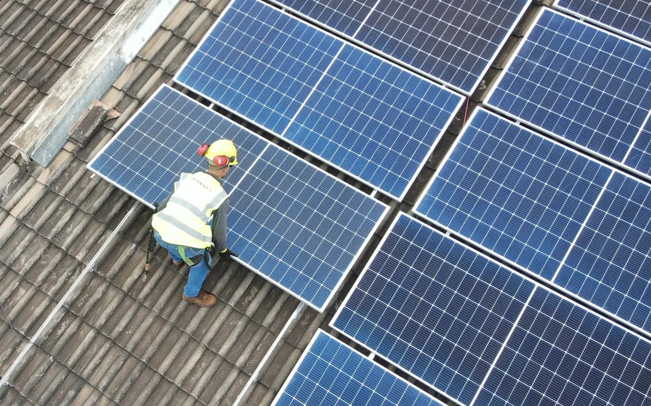 Técnico da Mensch instalando placas solares no telhado de um cliente